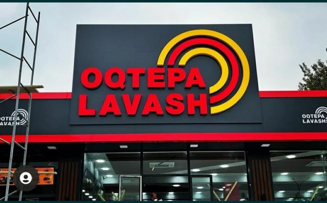 Oqtepa Lavash fasadidagi qizil va sariq hajmli harflar